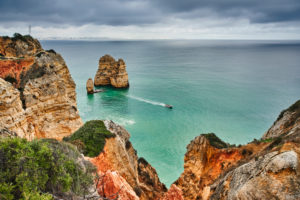 Europa, Portugal, Algarve, Litoral, Barlavento, Felsalgarve, Distrikt Faro, Lagos, Küstenabschnitt der Ponta da Piedade, vorgelagertes Felsenriff und kleines Motorboot Europa, Portugal, Algarve, Litoral, Barlavento, Felsalgarve, Distrikt Faro, Lagos, Küstenabschnitt der Ponta da Piedade, vorgelagertes Felsenriff und kleines Motorboot